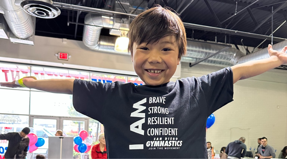 A kid wearing a shirt that says "I am brave, strong, resilient, confident"